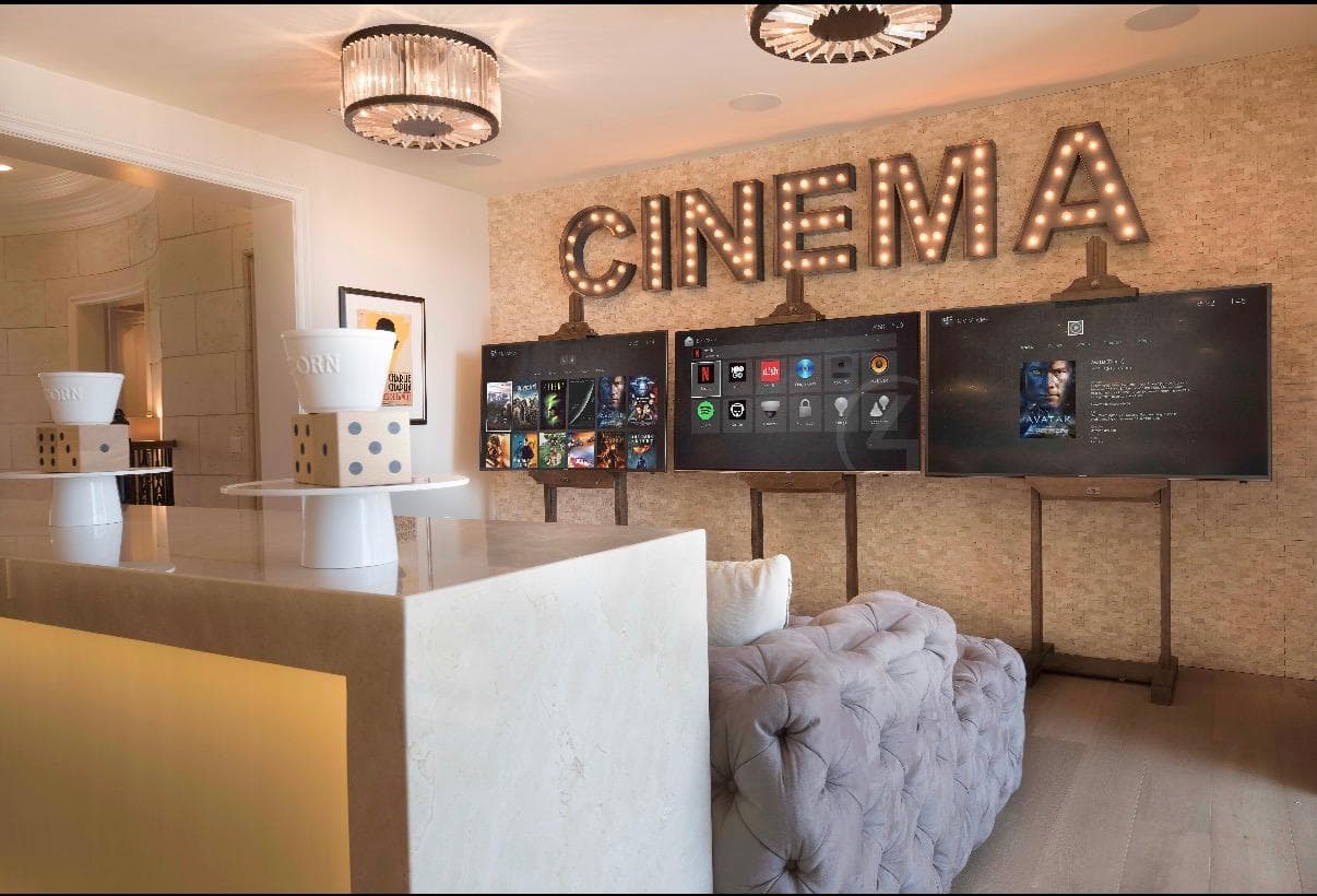 Dedicated cinema room with three displays and integrated ceiling speakers